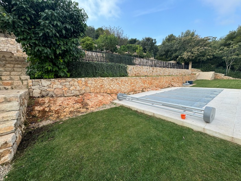 Mur de soutènement en pierre naturelle et aménagement paysager des abords de piscine pour une villa située à Mougins